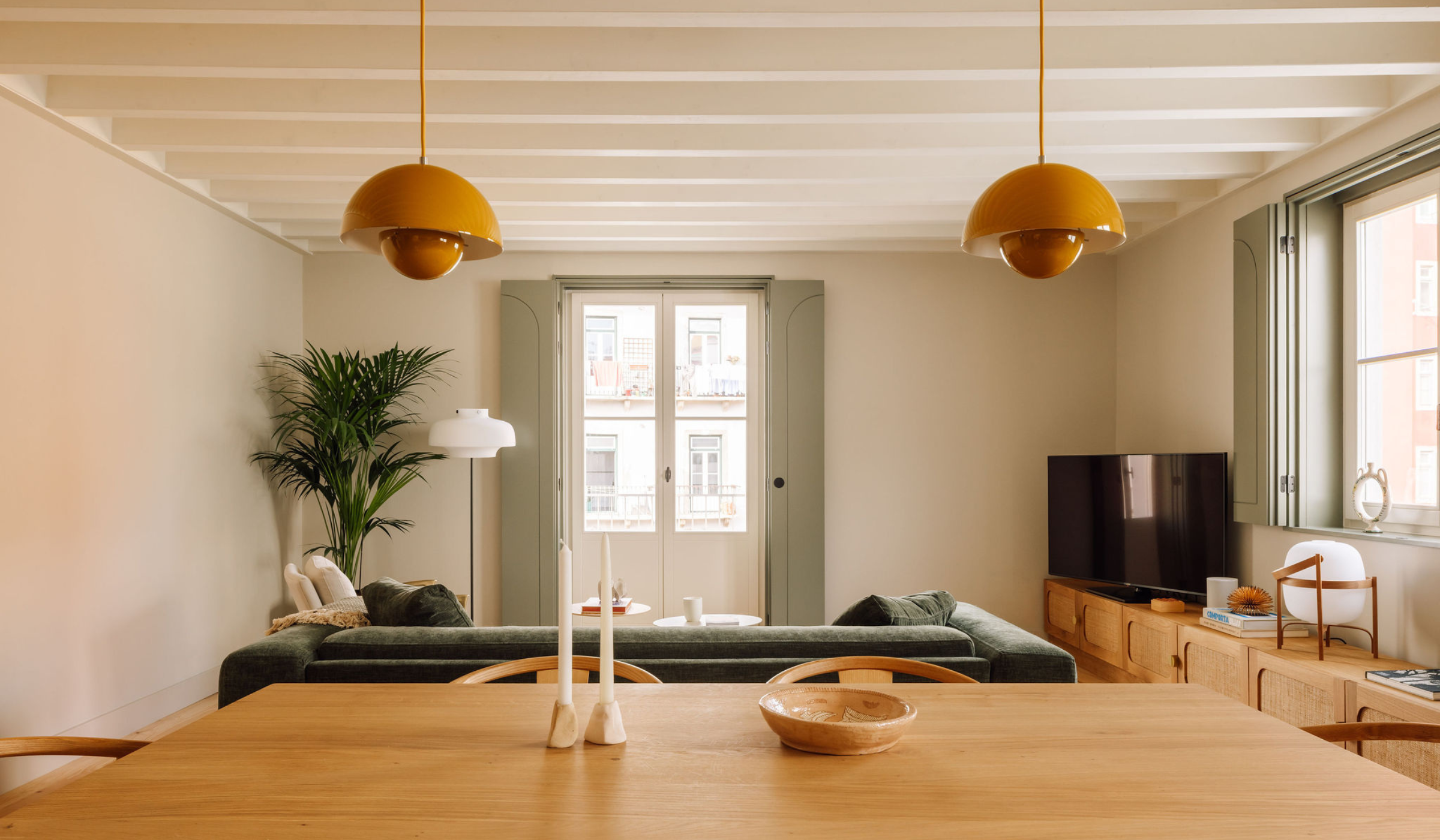Dyke & Dean website hero image with mustard pendant lights in a cozy living room/dining room setting.
